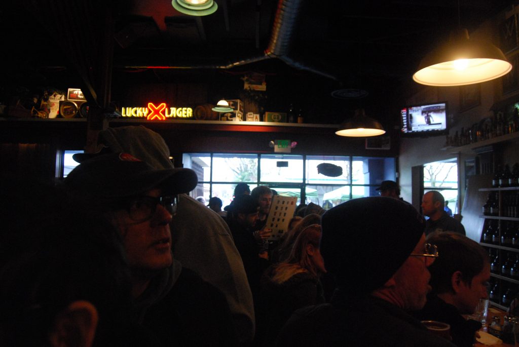 The front of the bar, near the entrance.